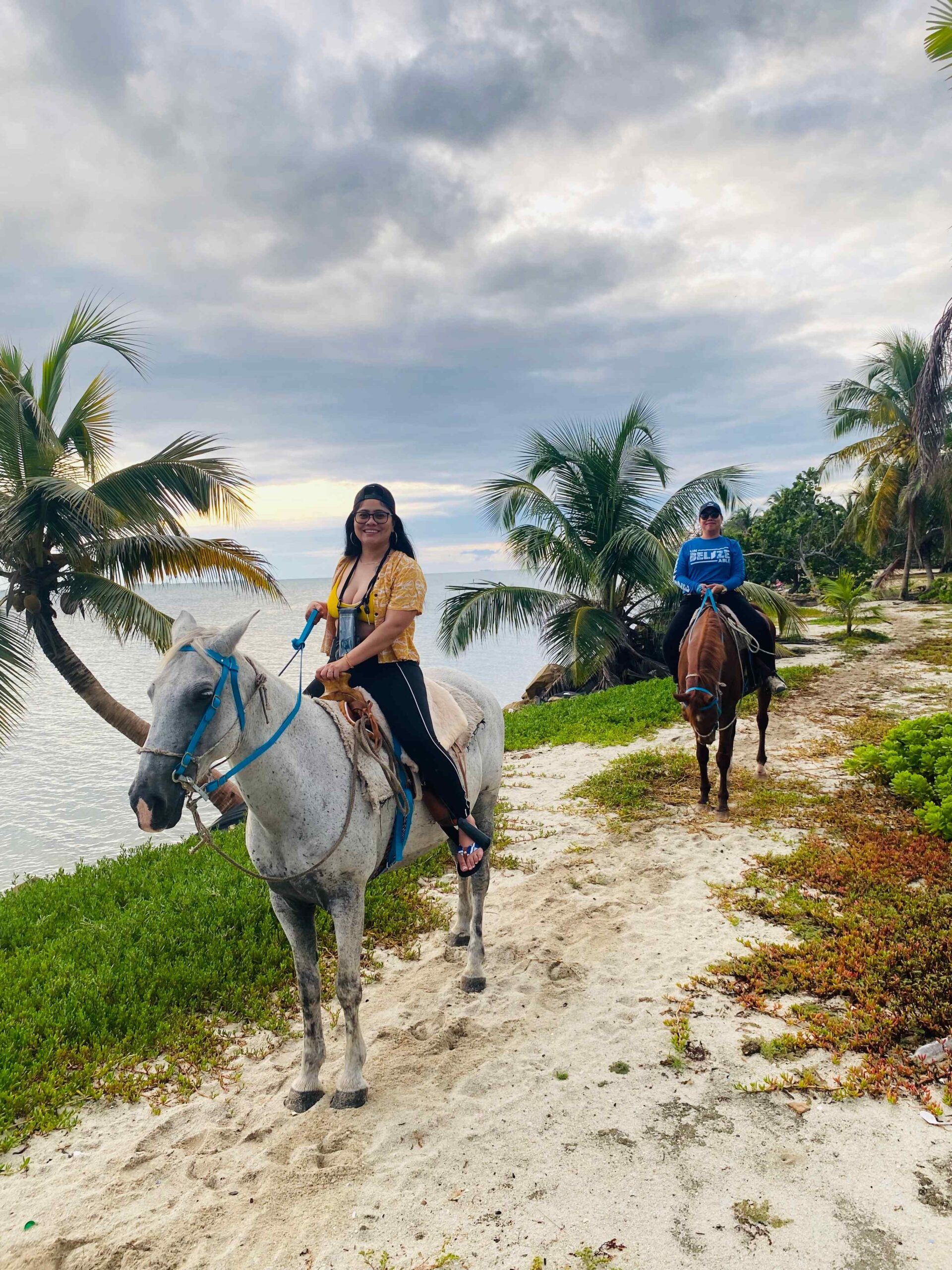 A person riding a horse along the shore of a beach in Placencia on a day ride.